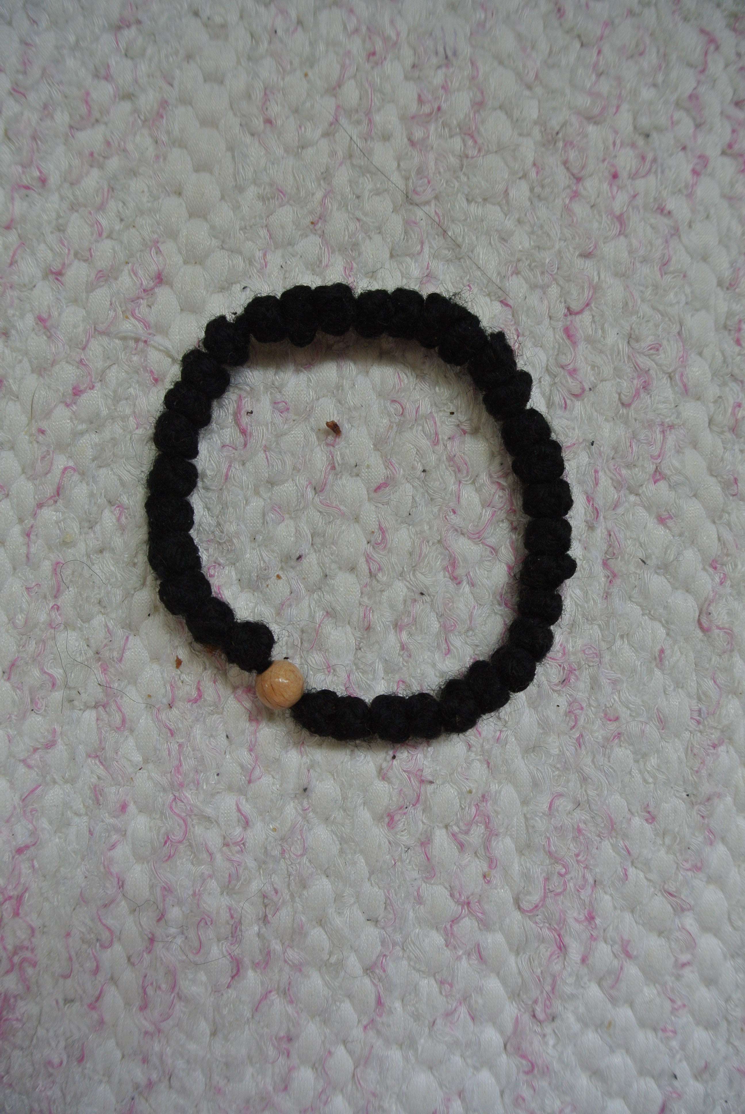 Pitkä harmaa rukousnauha yhdellä muovihelmellä